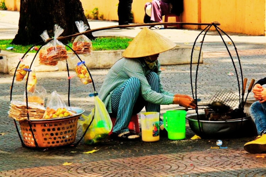 Vietnamese street food vendor in Hanoi selling snacks – Auasia Travel